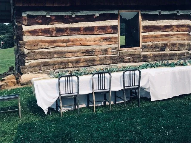 table and chairs next to log cabin