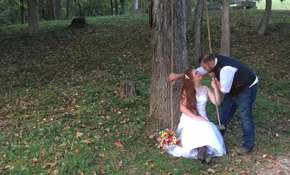 bride and groom kissing under a tree